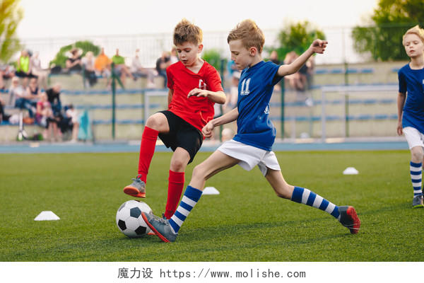儿童足球运动员在足球场上踢球